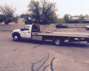 A tow truck is parked in a parking lot, ready to assist vehicles in need of towing services.